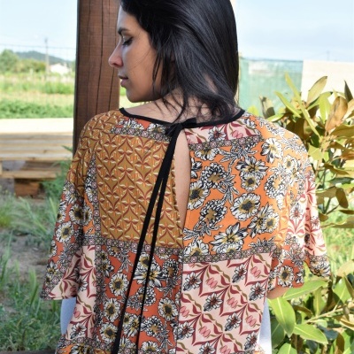 Blusa colorida com padrão patchwork e decote posterior com fita preta.