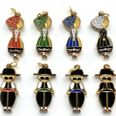Pendentes coloridos de figuras femininas e masculinas em metal esmaltado.