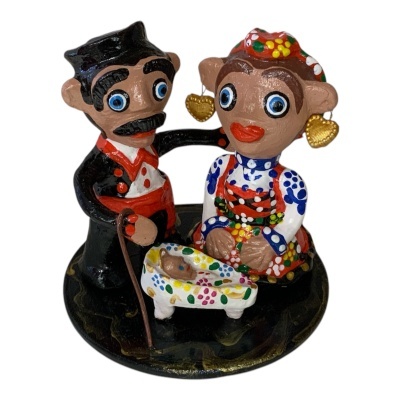 Figuras de casal tradicional em cerâmica colorida com berço