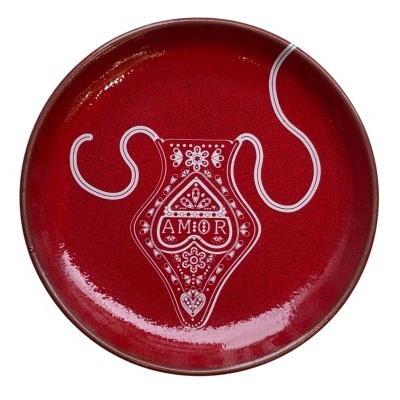 Prato redondo vermelho com padrão branco e palavra AMOR no centro