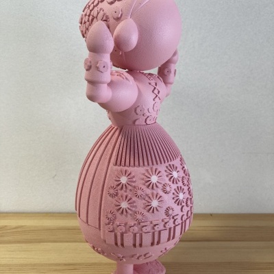 Boneca decorativa rosa com vestido texturizado e detalhes em relevo