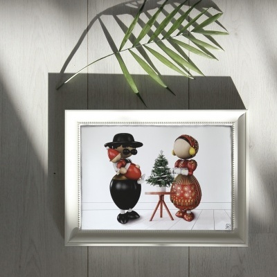 Quadro com figuras tradicionais e árvore de Natal em moldura branca.