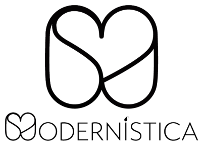 Dupla de cápsulas em metal castanho dentro de caixa cinzenta sobre mesa cinza clara com vasos brancos, vela e plantas