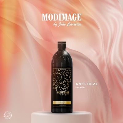 Frasco preto de champô Modimage Anti-Frizz sobre superfície branca com fundo rosa e laranja