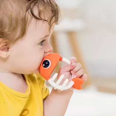 Criança com brinquedo em forma de peixe laranja e branco