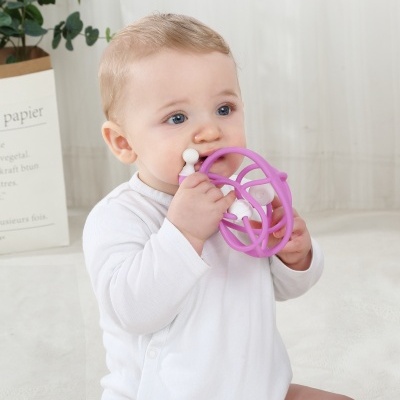 Bebé com brinquedo de borracha roxo e branco