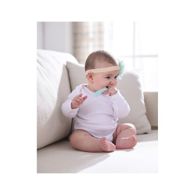 Bebé com fita de cabelo e escova de dentes azul sentado num sofá bege