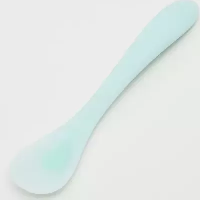 Colher azul clara de silicone sobre fundo branco