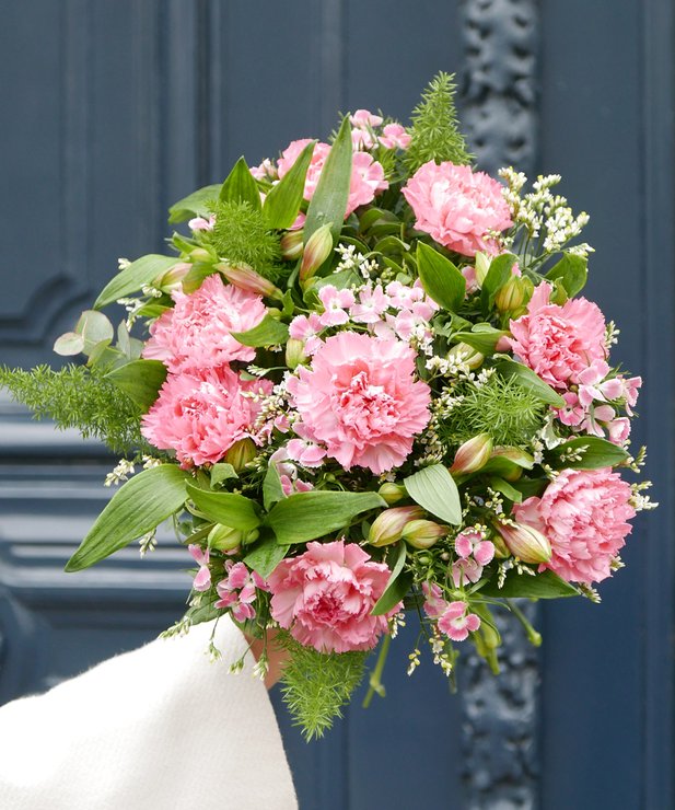 Ramo de flores cor-de-rosa e verdes em fundo de porta azul-escura