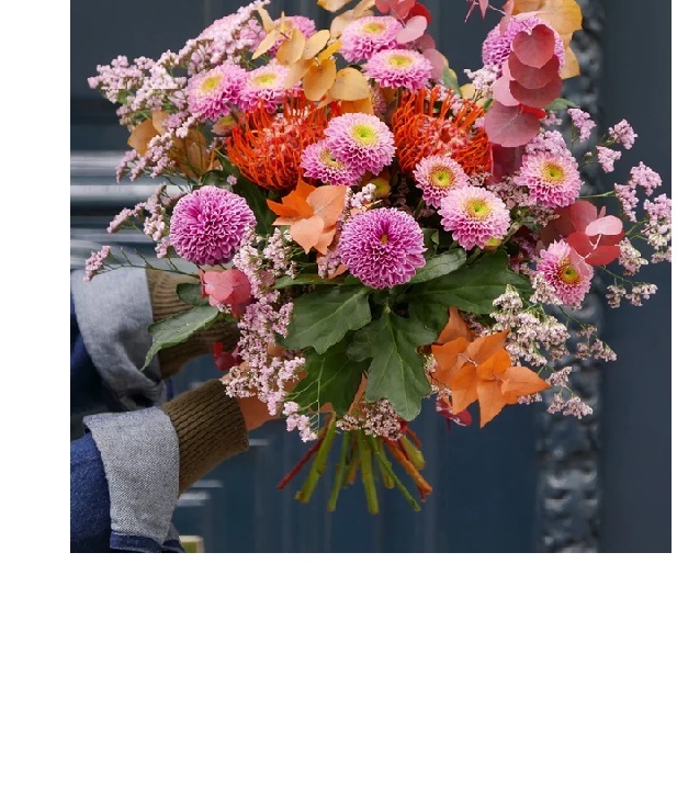 Buquê colorido de flores segurado por mão com luva