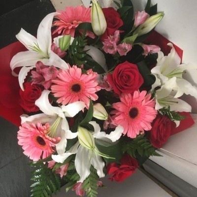 Bouquet colorido com lírios brancos, rosas vermelhas e gerberas cor-de-rosa