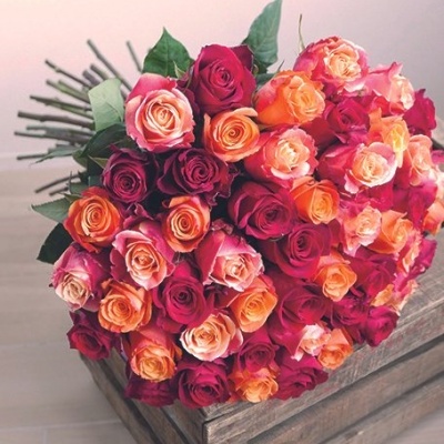 Bouquet de rosas multicoloridas sobre caixa de madeira