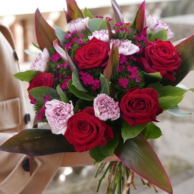 Bouquet de flores com rosas vermelhas, cravos cor de rosa e folhas verdes