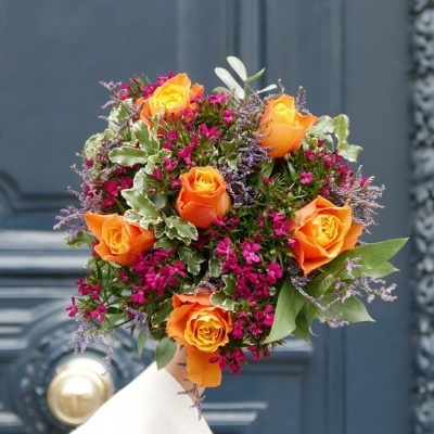 Bouquet de flores multicoloridas com rosas laranja e pequenas flores cor de rosa