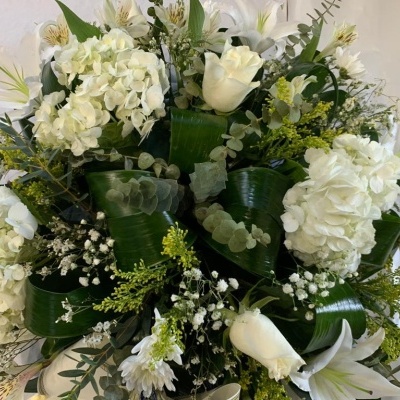 Arranjo floral com flores brancas e folhas verdes