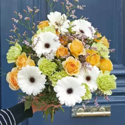 Buquê colorido de flores contra porta azul