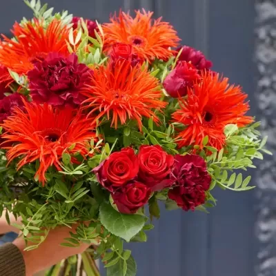 Buquê colorido de rosas, gérberas e cravos com folhagens verdes