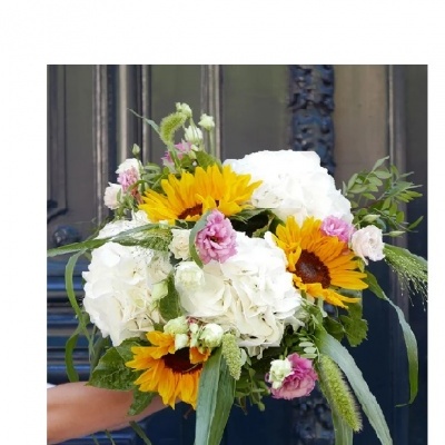 Ramo de flores com girassóis, flores brancas e rosas e folhagem verde