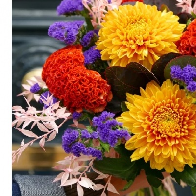 Arranjo floral colorido com flores amarelas, vermelhas e roxas