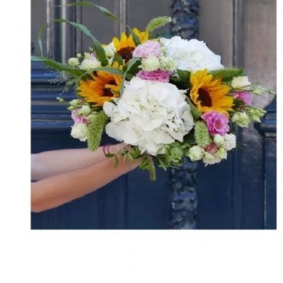 Buquê colorido com girassóis, flores brancas e rosas, folhas verdes