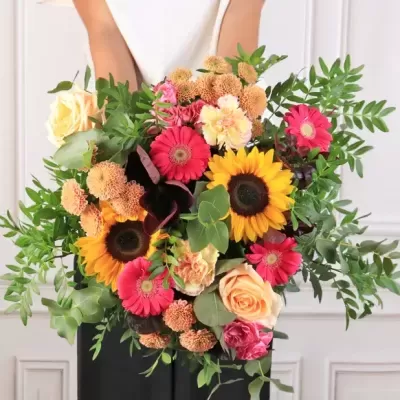 Buquê colorido de flores com girassóis e rosas em mãos