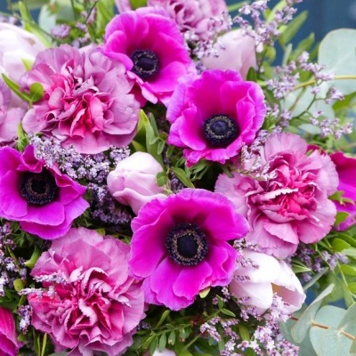 Bouquet colorido de flores roxas e rosas com folhagem verde