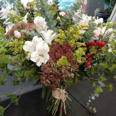 Bouquet colorido de flores com lírios brancos e folhas verdes em mesa escura