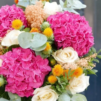 Ramo de flores com flores cor-de-rosa, rosas brancas, flores amarelas, folhas verdes e cinzentas