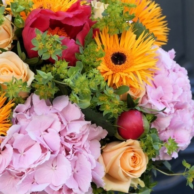 Buquê colorido de flores amarelas, rosas e laranja com folhagem verde