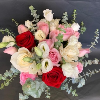 Buquê de flores com rosas vermelhas, rosas e brancas e folhagem verde