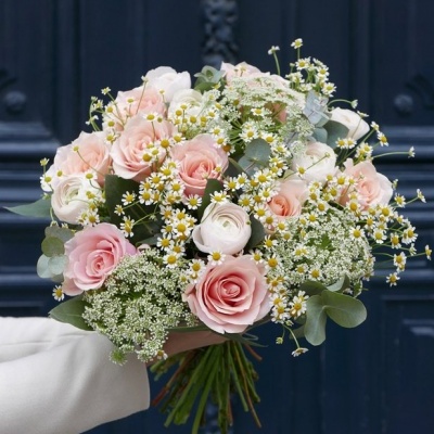Buquê de flores rosas e brancas com folhas verdes em fundo de porta azul escura