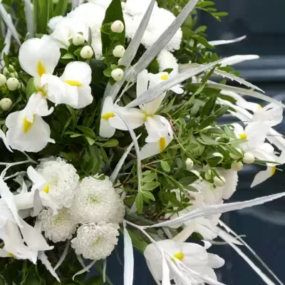 Arranjo floral branco com folhas verdes e detalhes prateados