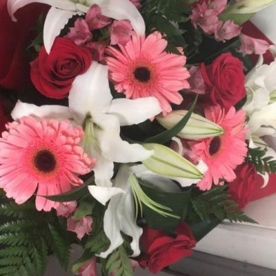 Buquê colorido com lírios, rosas e gerberas sobre superfície branca