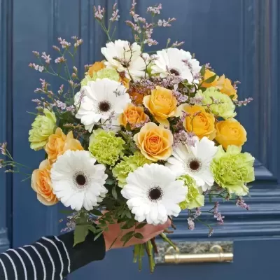 Buquê de flores coloridas tenras em frente a uma porta azul escura