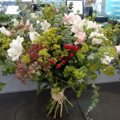 Arranjo floral colorido com flores brancas, verdes e vermelhas, amarrado por cordão natural