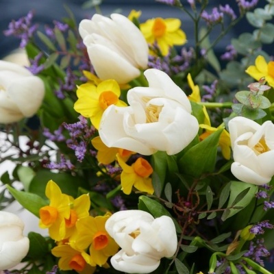 arranjo floral com tulipas brancas e flores amarelas e roxas