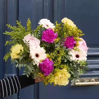 Ramo de flores multicolorido contra porta azul escura