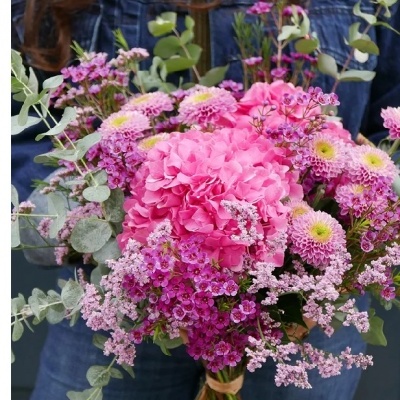 Bouquet de flores rosas e lilás com folhagem verde