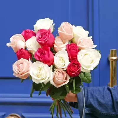 Bouquet de rosas coloridas segurado em frente a porta azul