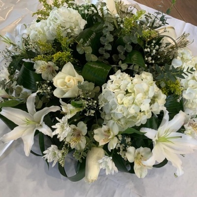 Arranjo floral com flores brancas e folhagem verde