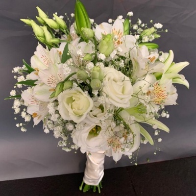 buquê de flores brancas com fita branca em fundo cinzento