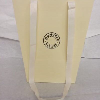 Saco de papel amarelo com alças brancas e logótipo MONCEAU FLEURS