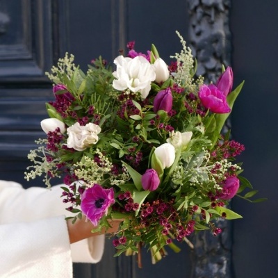 Ramo de flores brancas, rosas e roxas com folhagem verde