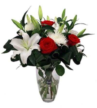 Arranjo floral com rosas vermelhas, lírios e crisântemos brancos em vaso de vidro