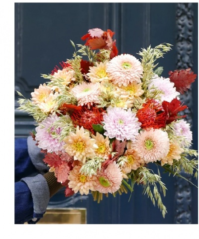 Ramo colorido de flores com tons de rosa, branco e vermelho seg. por mão com manga azul