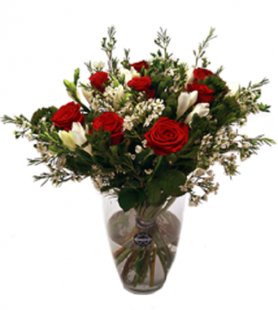 Bouquet de rosas vermelhas e flores brancas num vaso de vidro transparente