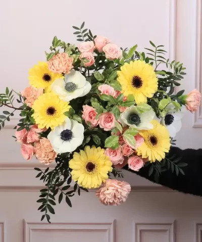 Ramo colorido de flores amarelas, brancas e cor de rosa com folhagem verde