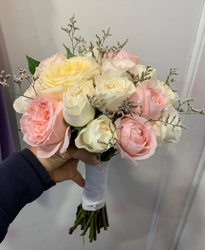 Ramo de flores com rosas creme, branco e rosa claro envolto por fita branca