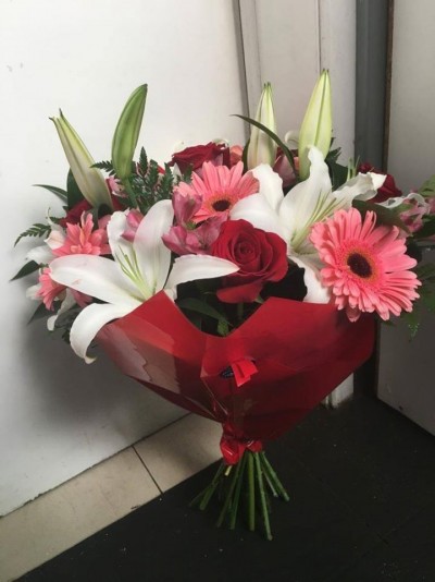 Bouquet de flores coloridas embrulhado em papel vermelho