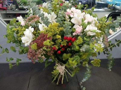 Arranjo floral colorido em vaso com flores e folhas verdes
